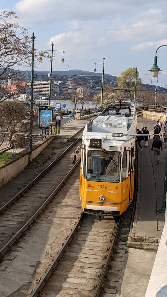About us - with a picture of Budapest Tram 2 Line in Spring